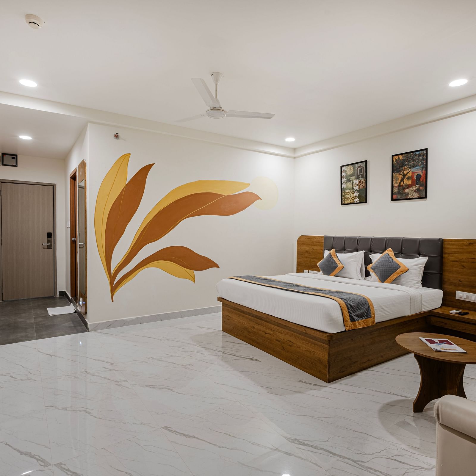 Bright premium room with painted wall mural, comfortable bed, and stylish furniture at Lemonridge Hotels, IDPL Balanagar.