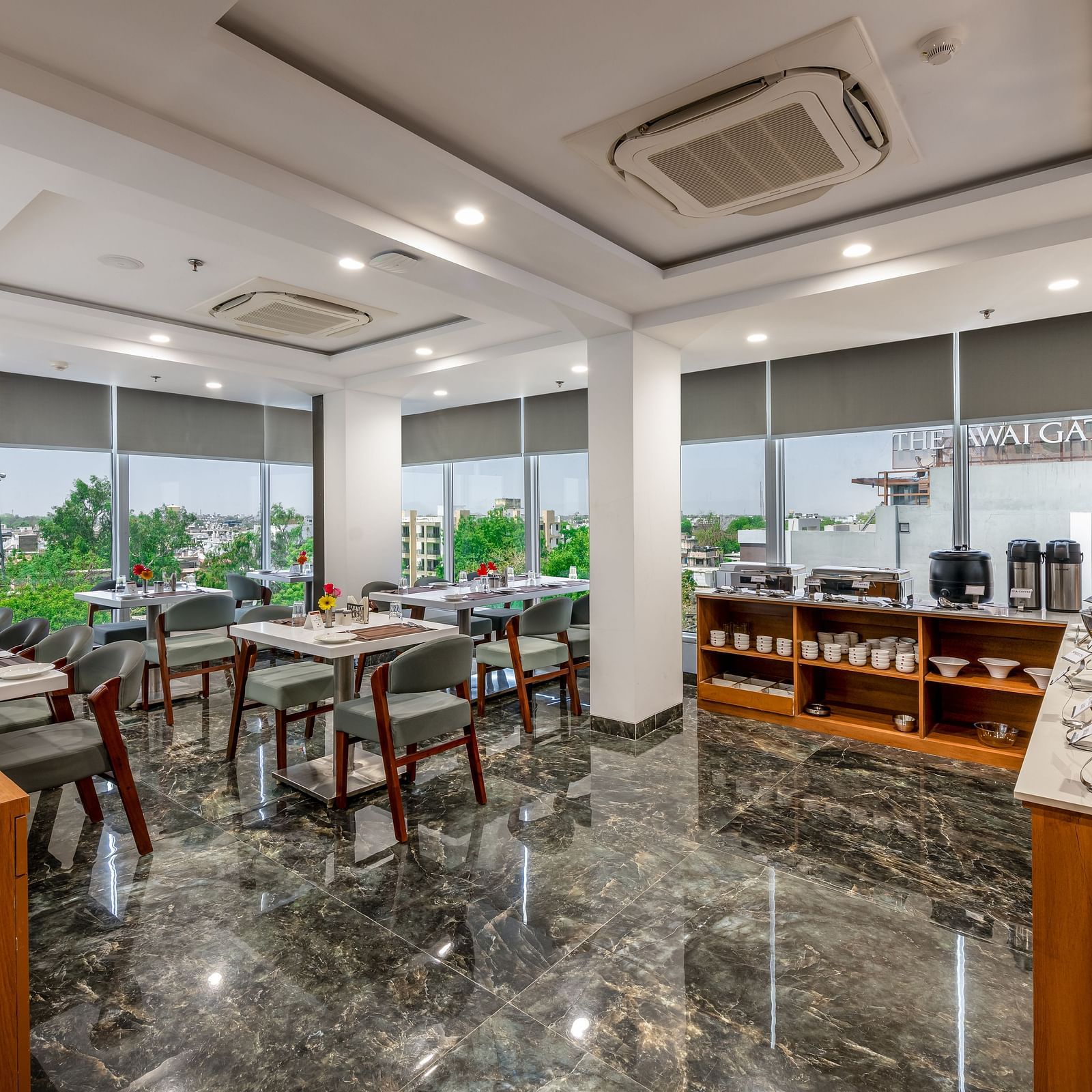 Spacious BCR restaurant dining area with large windows, multiple tables & chairs and the marble flooring.