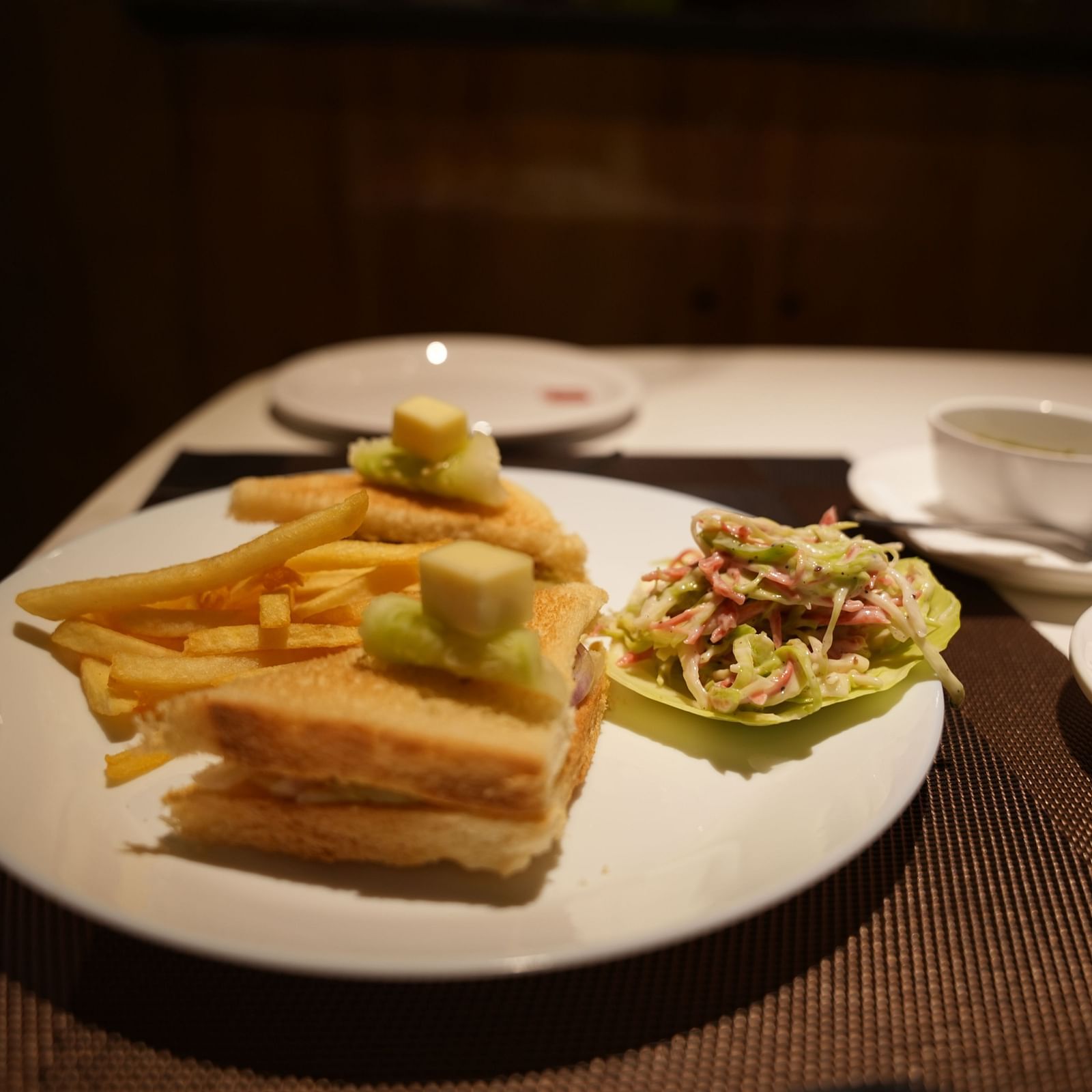 a plate of sandwich, and fries placed on a dining table
