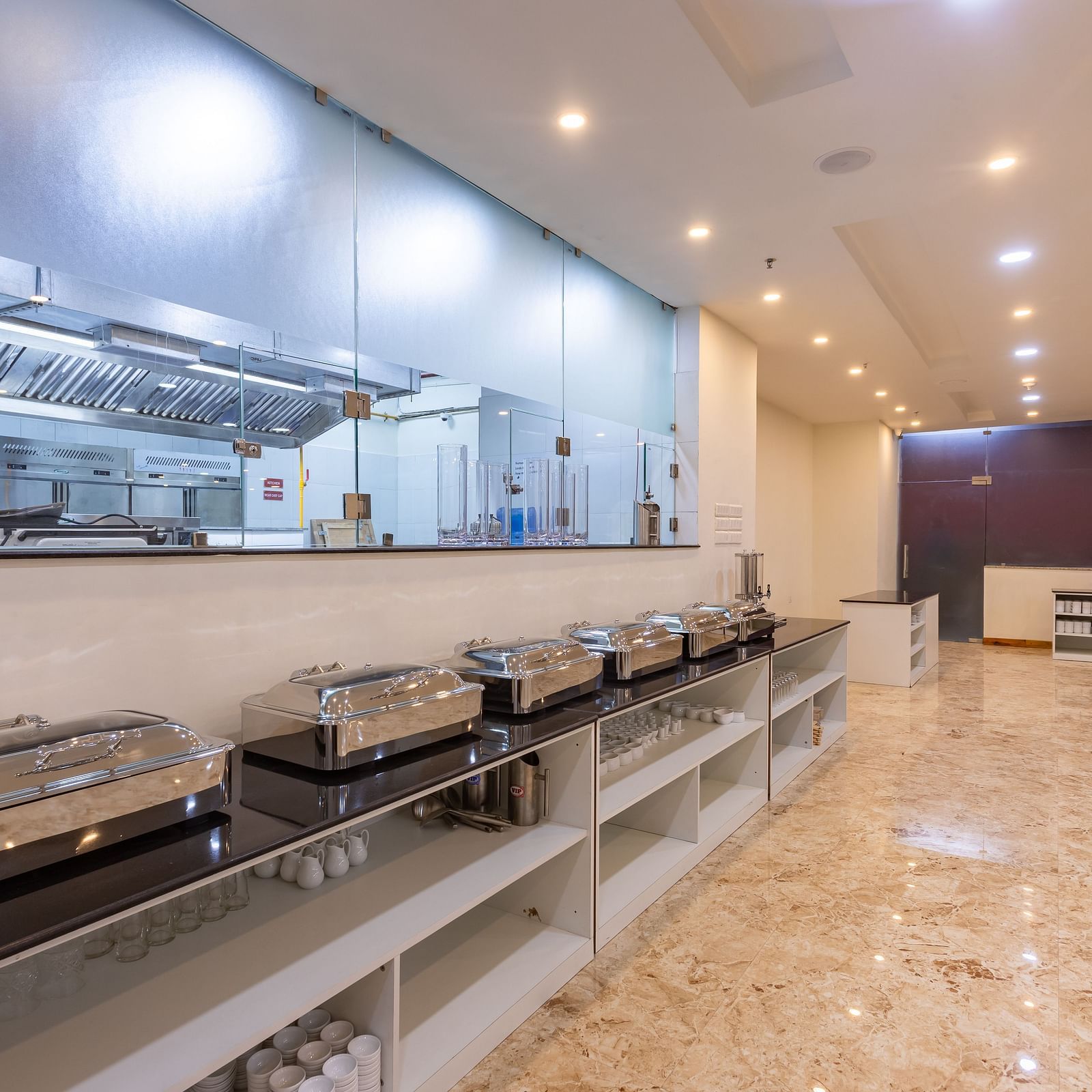 Buffet corner of the Blue Coriander Restaurant that has overhead lighting and a spacious arrangement at Mandala Norling Lords Prime in Kathmandu.
