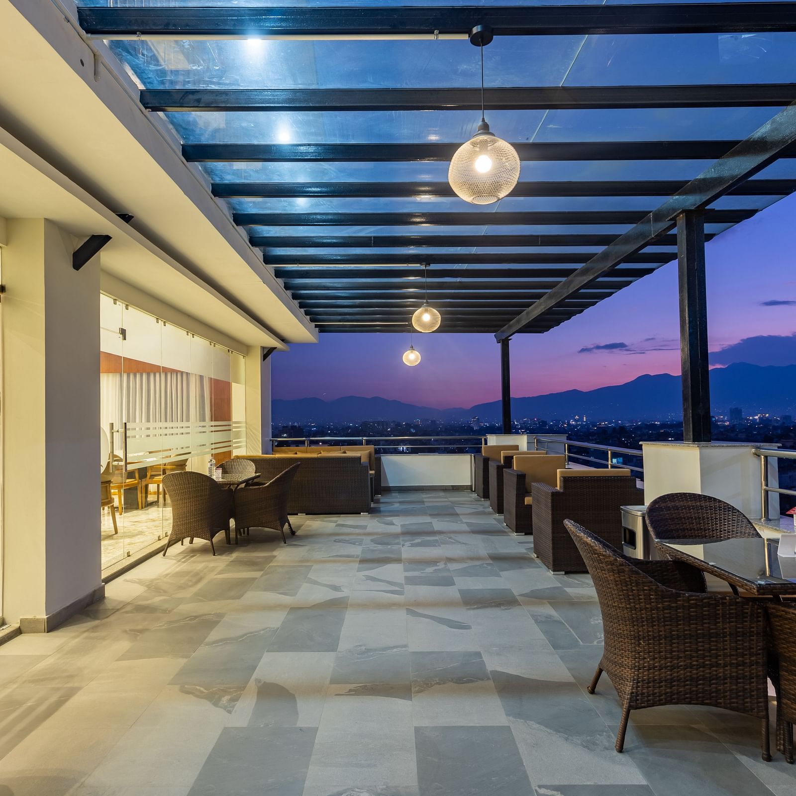 Outdoor seating arrangement at Mandala by Lords featuring a spacious corridor with a covered ceiling and picturesque views.