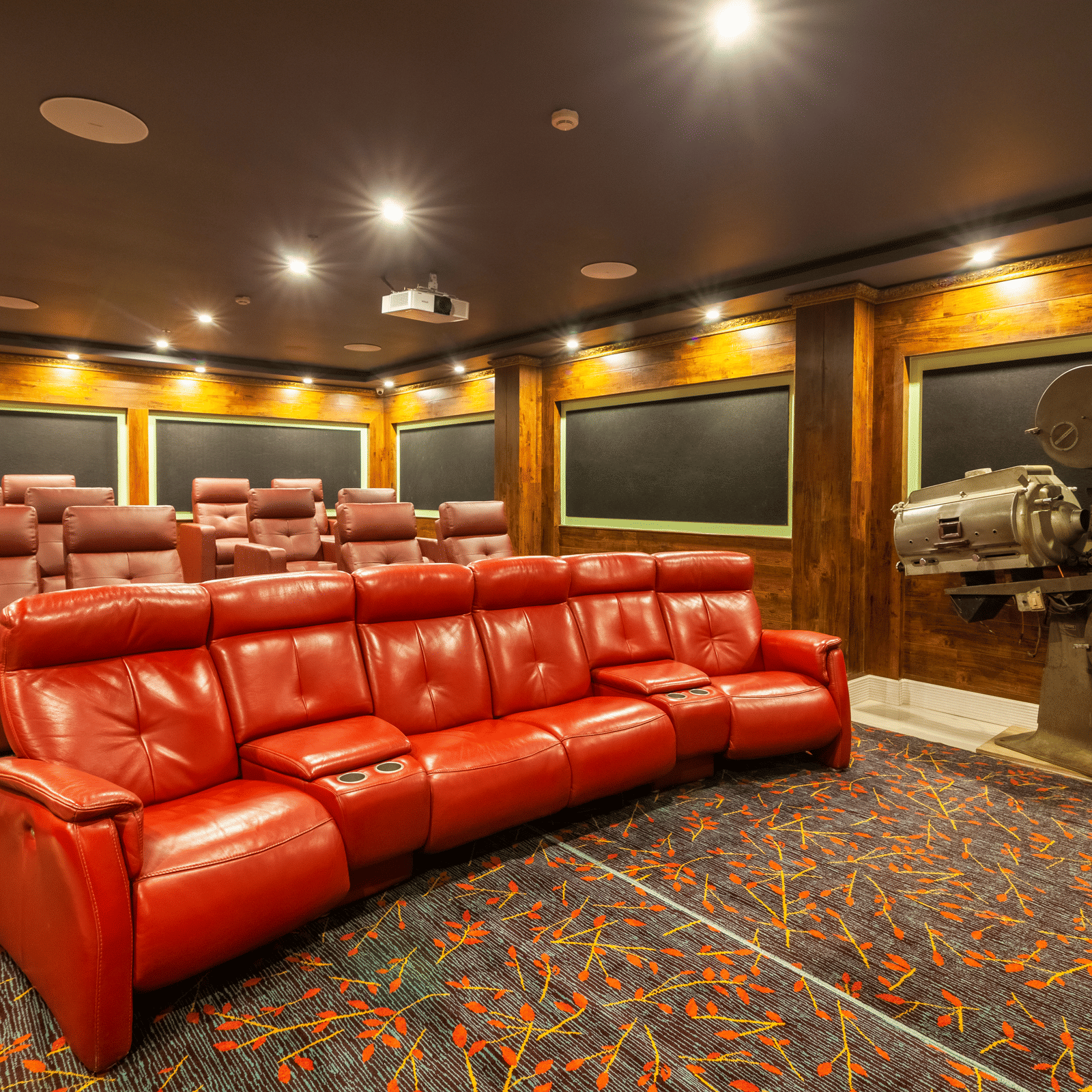 Box Office private theatre with red leather recliner seats, acoustic wall panels and a vintage film projector at MAYFAIR Himalayan Spa Resort, Kalimpong.