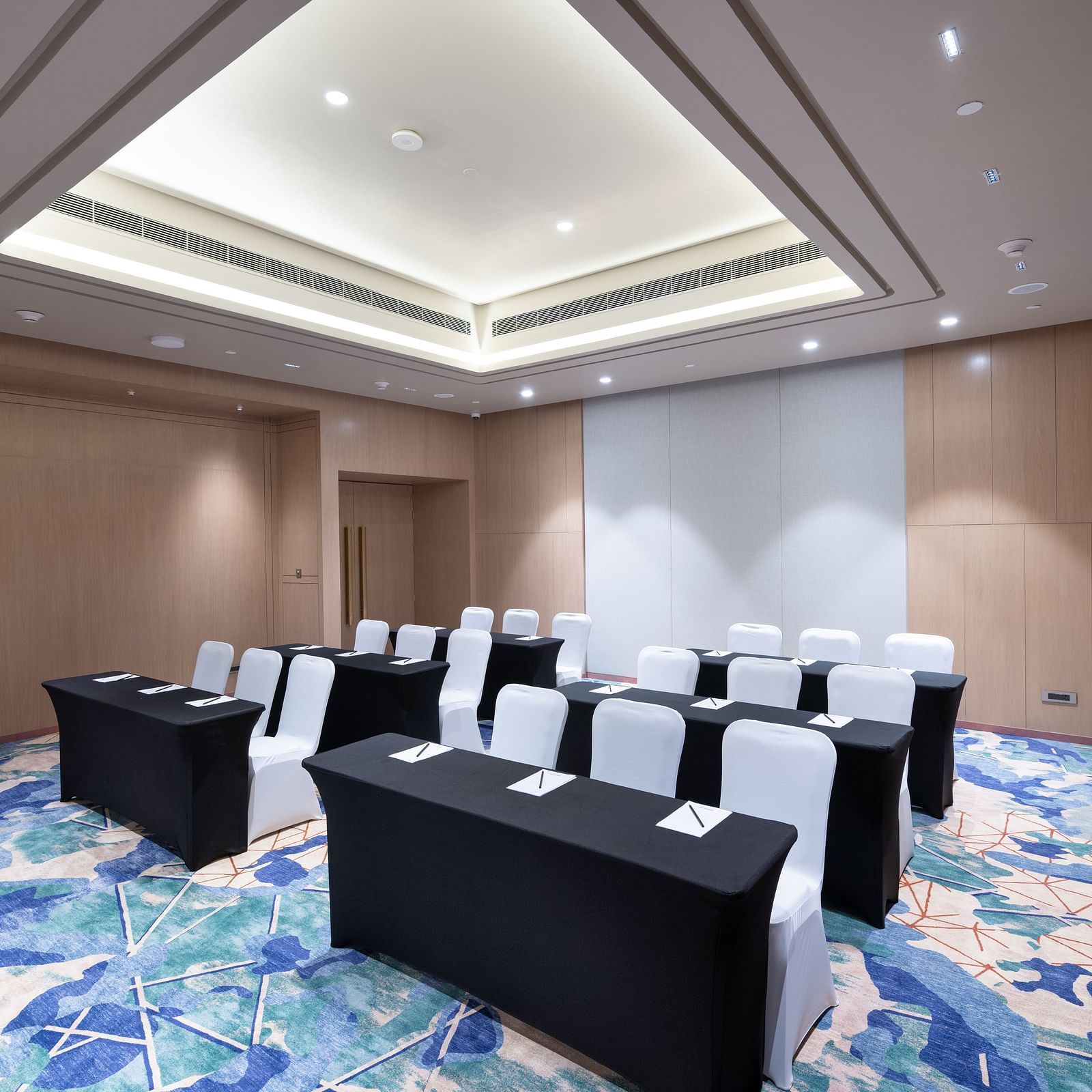 Spacious room with modern U-shaped table arrangement at Merlis Hotel, Coimbatore.