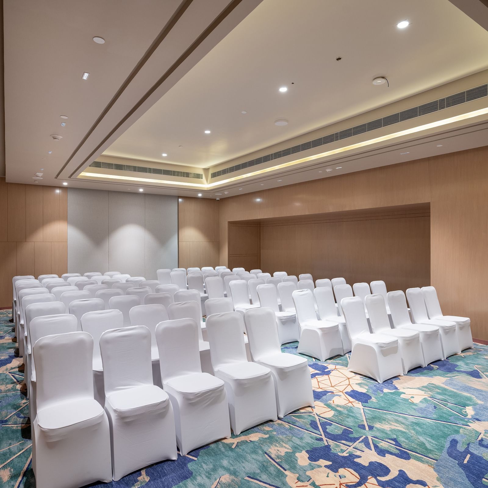 Side view of theatre-style seating arrangement in a function space at Merlis Hotel, Coimbatore.