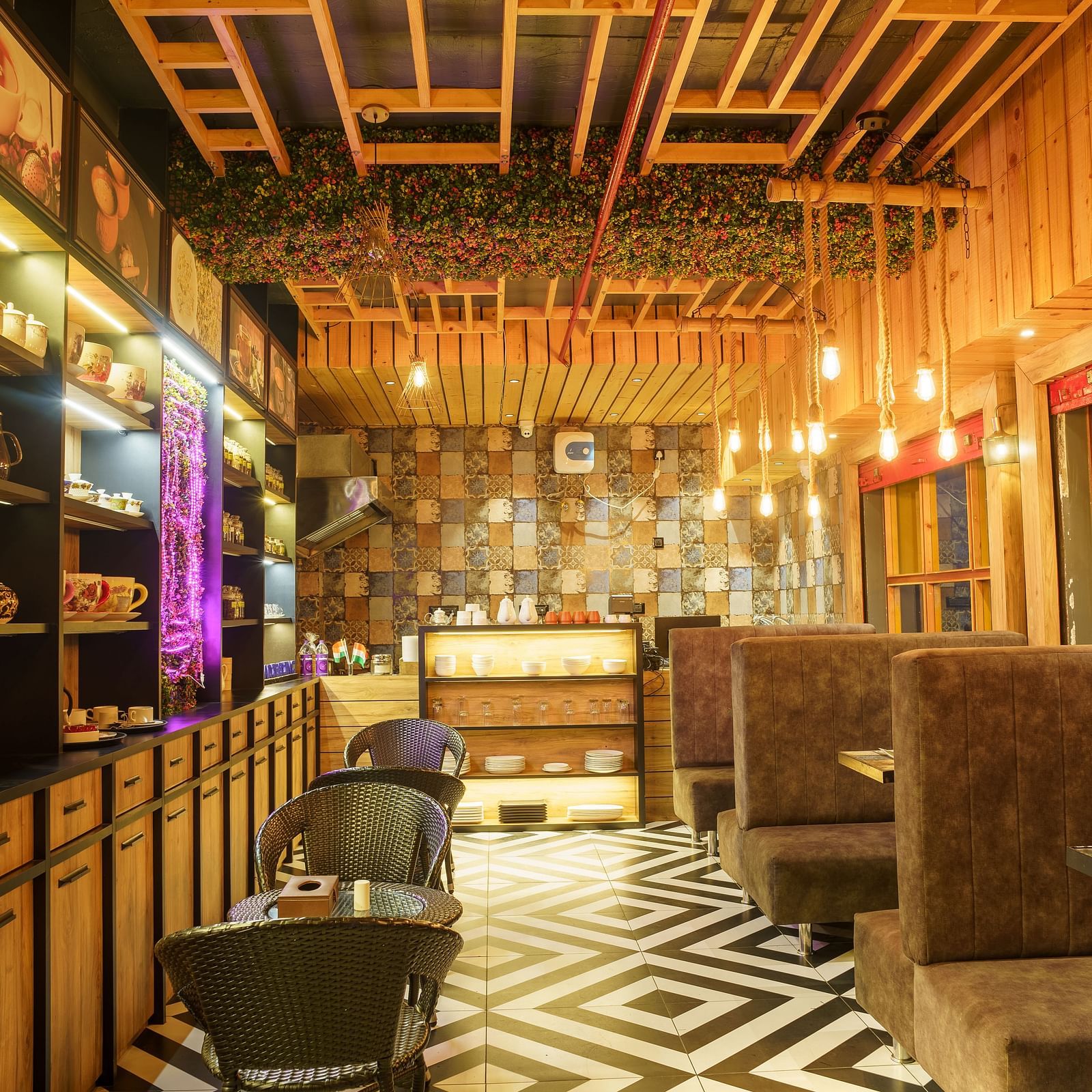 A restaurant with wooden panelled walls and ceiling, dark seating, and decorative hanging lights at Orsino Spa Resort.