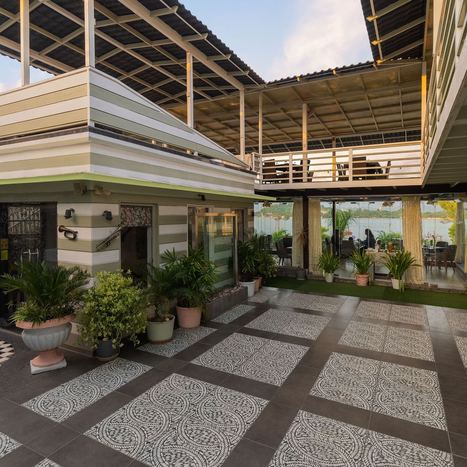 Rooftop restaurant entrance of Panna Vilas Palce features potted plants for decoration, with glass panels separating the dining area.