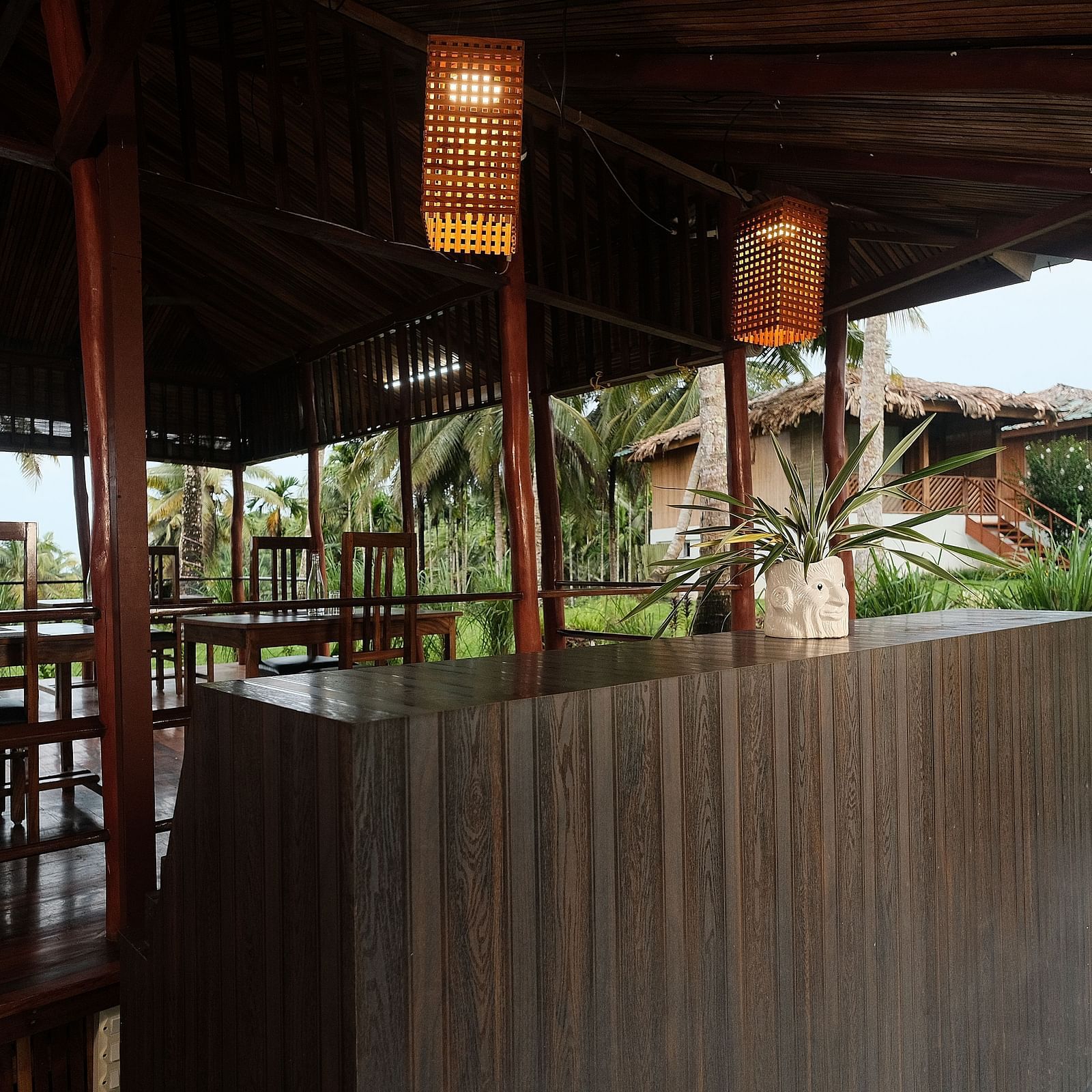 A view of the restaurant's outdoor dining area, with wooden tables and chairs set against a natural backdrop | Fusion Cafe and Multi-cuisine | RainForest Resort, Port Blair, Andaman and Nicobar Island