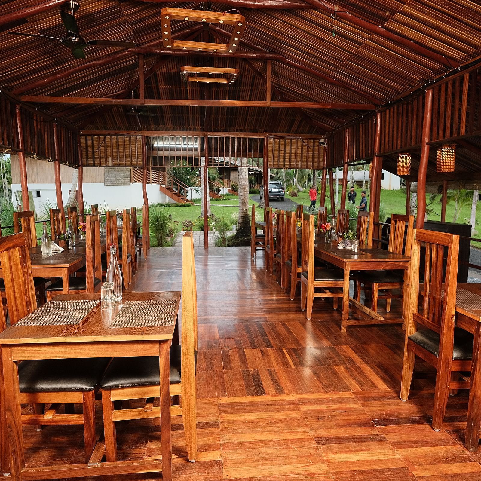 A dining table set for a meal inside the restaurant, with a view of the surrounding wooden interior | Fusion Cafe and Multi-cuisine | RainForest Resort, Port Blair, Andaman and Nicobar Island