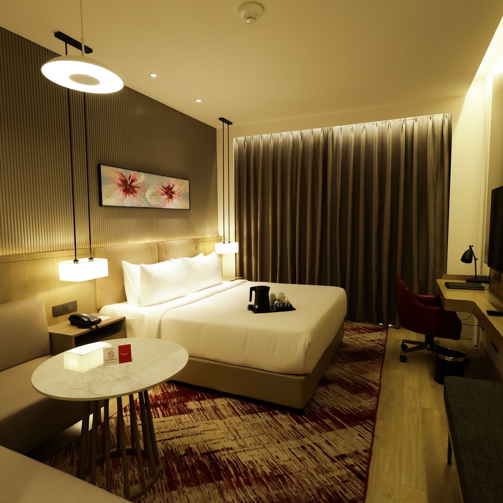 Modern room with work desk, sofa seating, and ambient lighting at Ramada by Wyndham Sonipat Murthal