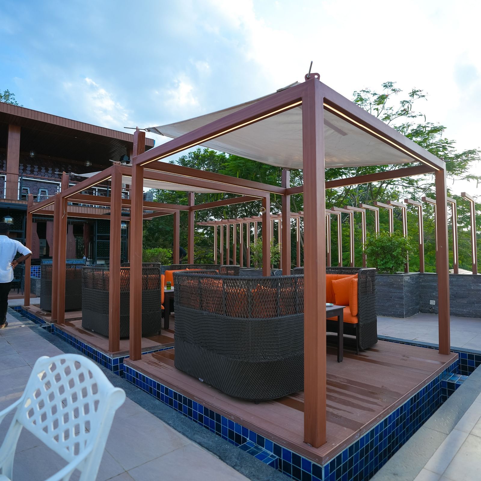 Side view of the open dining area with seating arrangements at Sathyam Grand Hotels