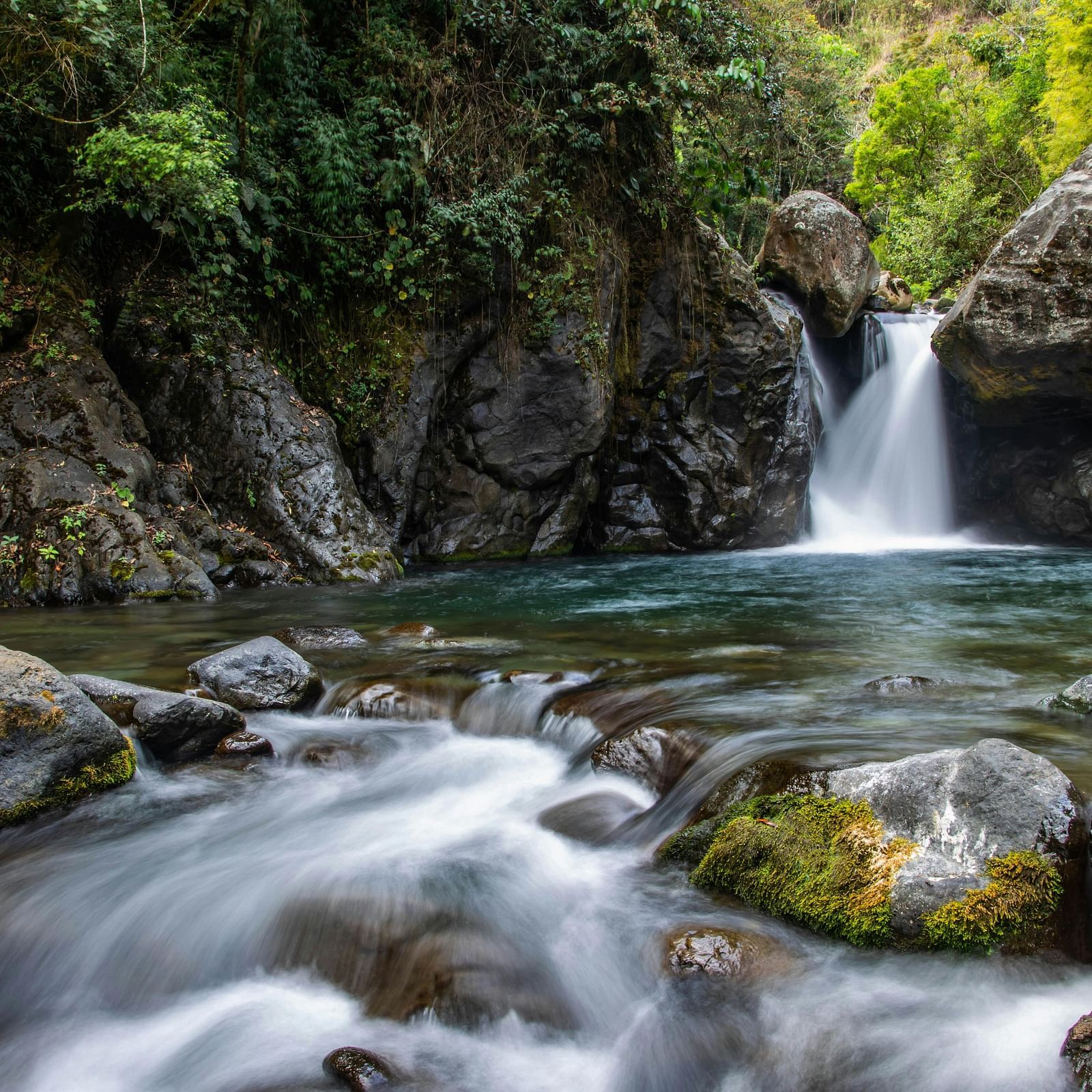 View of Corbett waterfall with rocks and surrounded by trees.