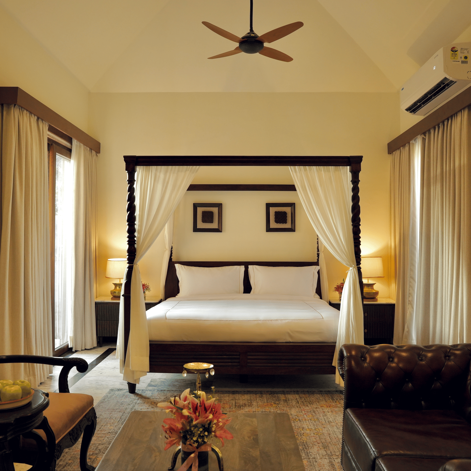 A room with a bed and a seating area in front at Surpura Bagh.