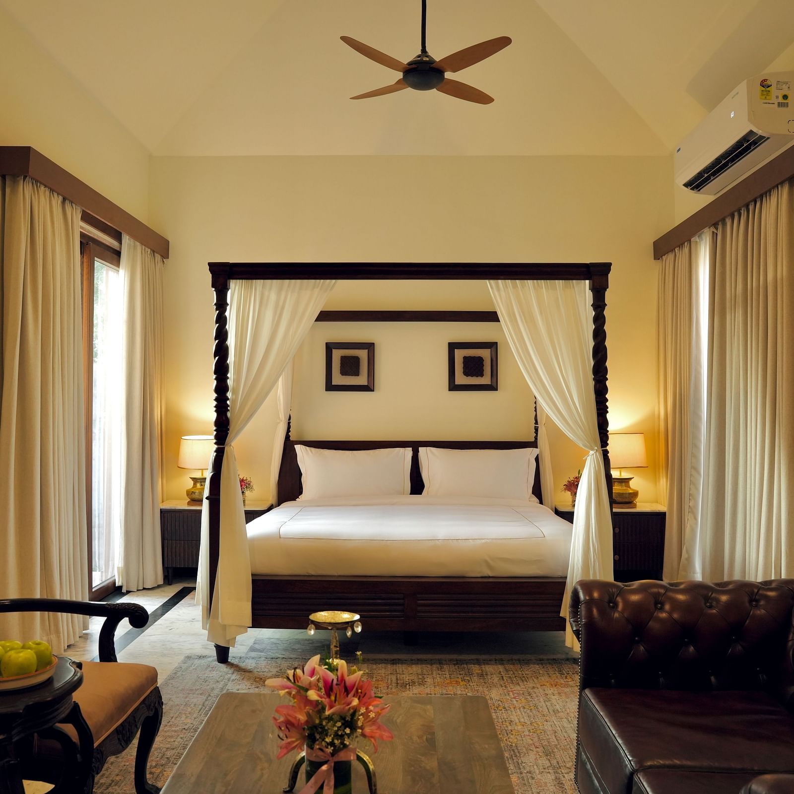 A room with a bed and a seating area in front at Surpura Bagh.