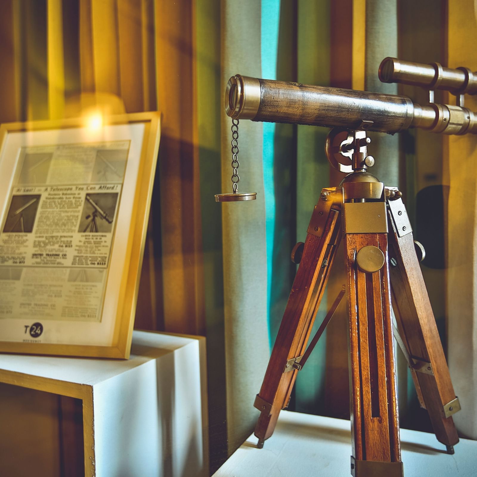 An old telescope with an illustration depicting its working placed beside it at T24 Residency, Andheri East, Mumbai