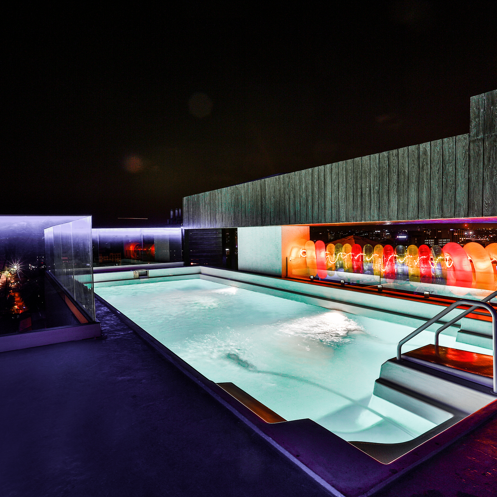 A well-lit rooftop swimming pool at T24 Residency, Andheri East, Mumbai at night