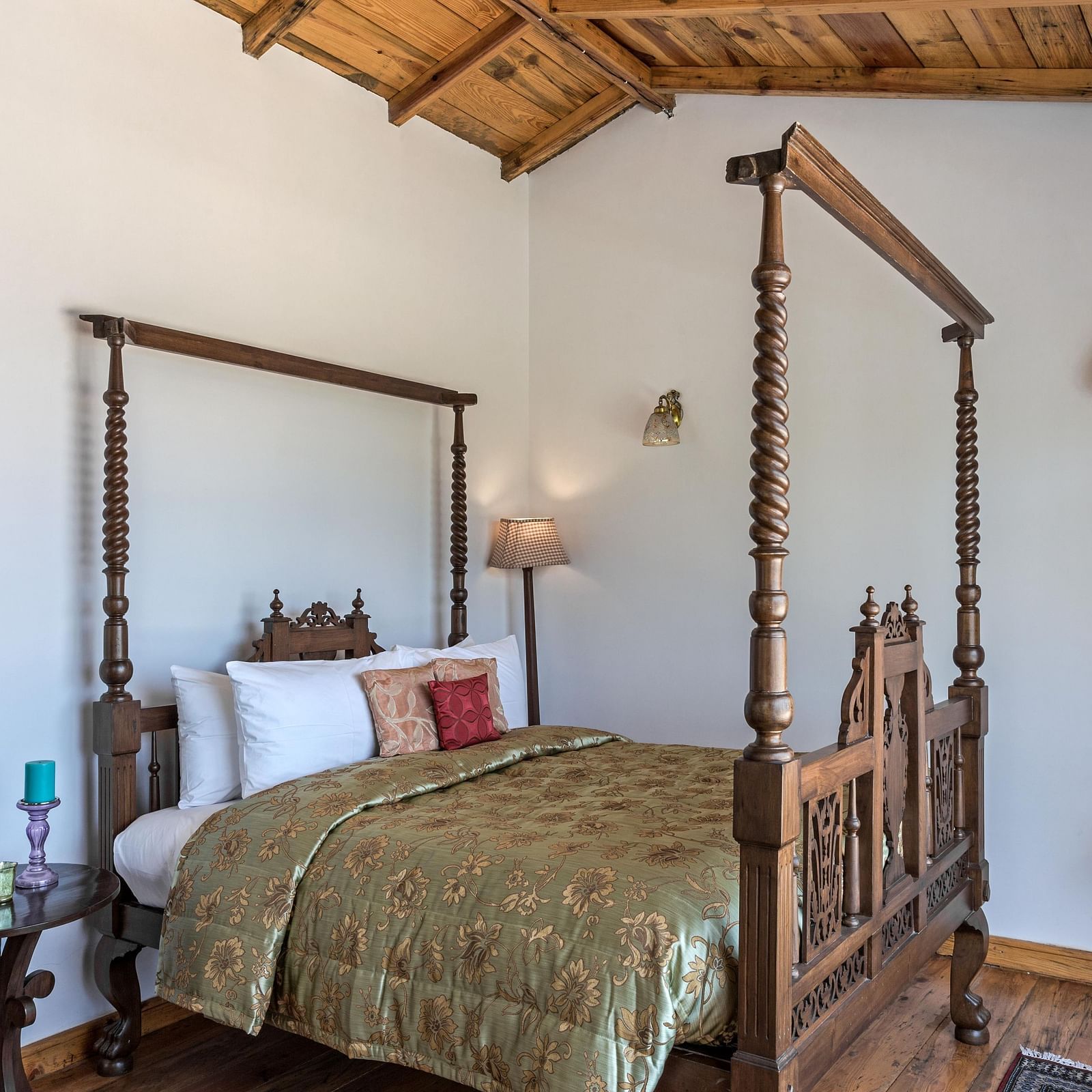 Side view of the  Superior Room  bed with wooden frames and lamp placed on the side of the room at Te Aroha by Shervani Mukteshwar