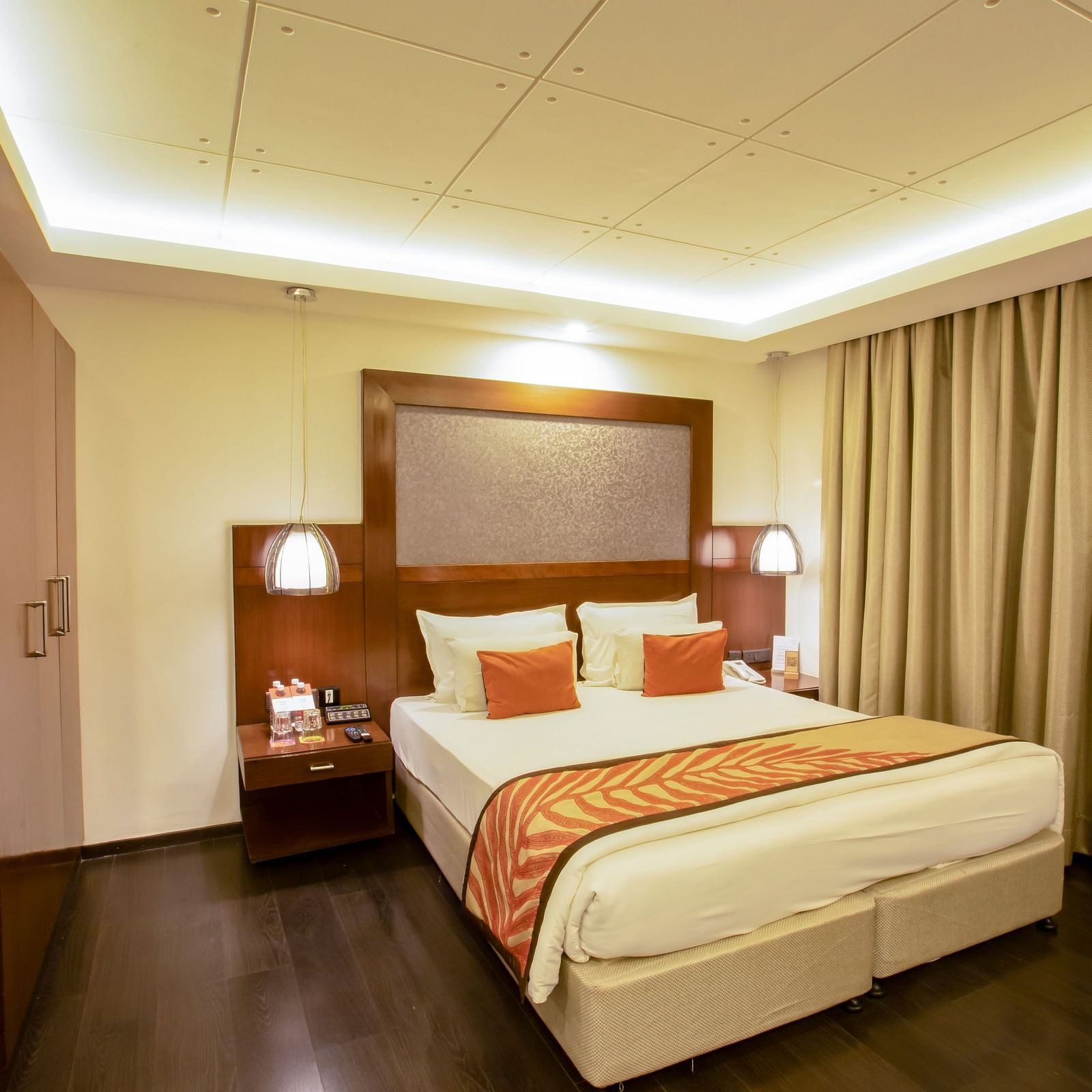 Studio Room at The Cunningham Hotel with warm lighting, elegant wooden decor, plush bedding, and cosy ambience