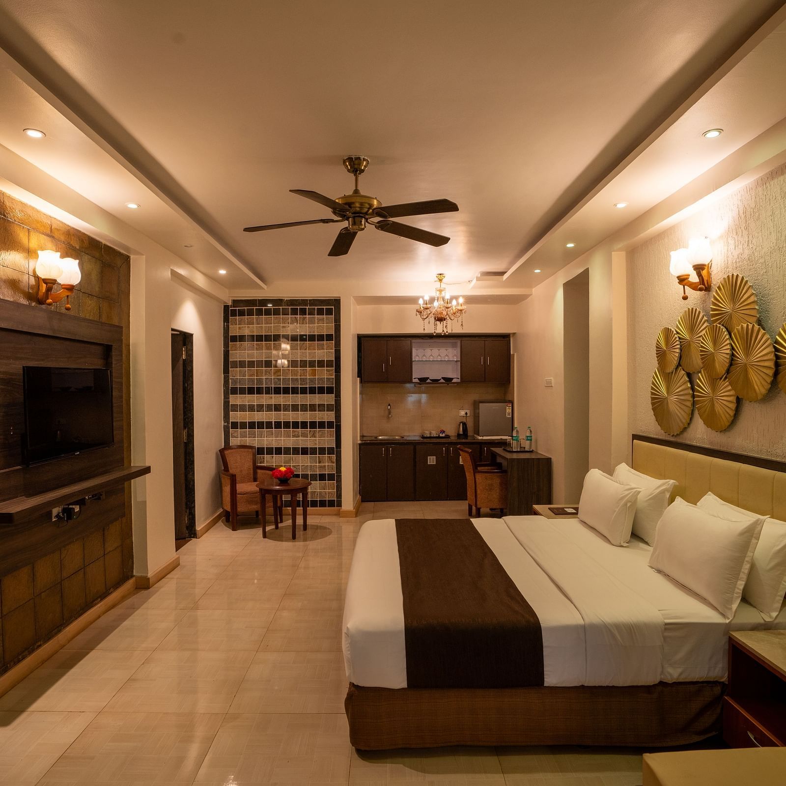 Interior view of a guest room with a seating area, ceiling fan, and wall décor - The Grand Legacy Resort & Spa