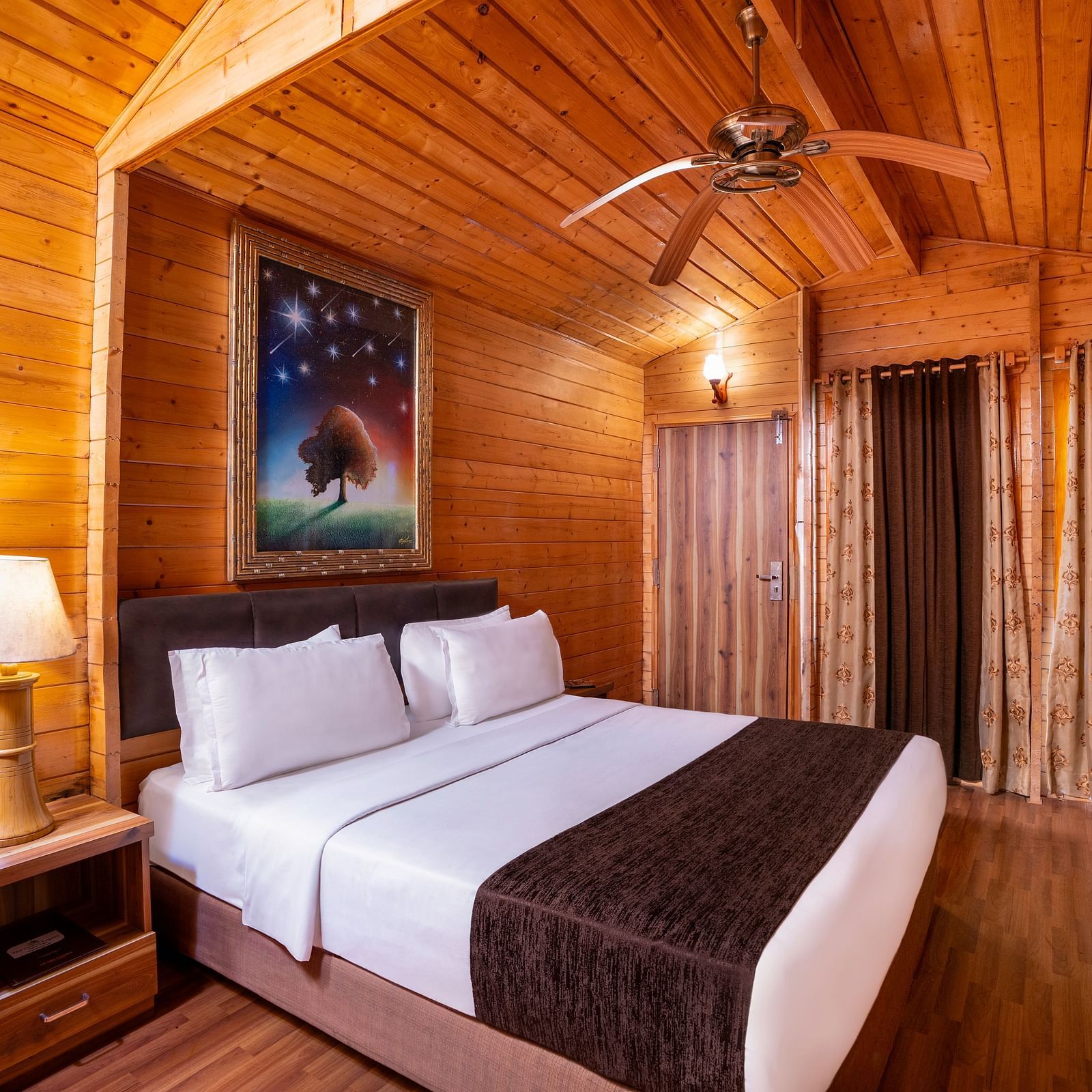Cosy wooden room with twin beds, nightstand, and ceiling fan - The Grand Legacy Resort & Spa