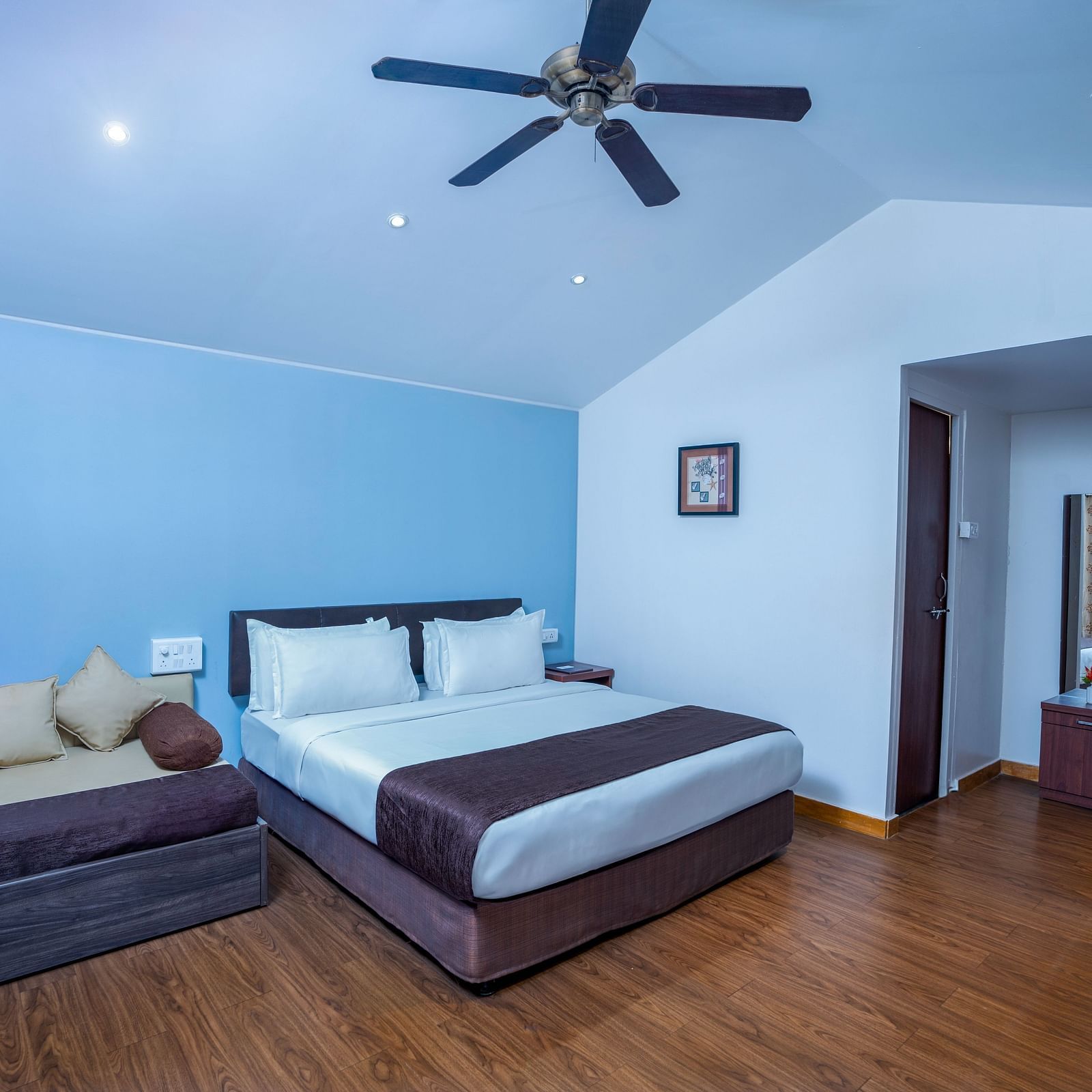 A image of a spacious room with a king size bed and a couch along with several  wall decors | The Grand Legacy Resort and Spa