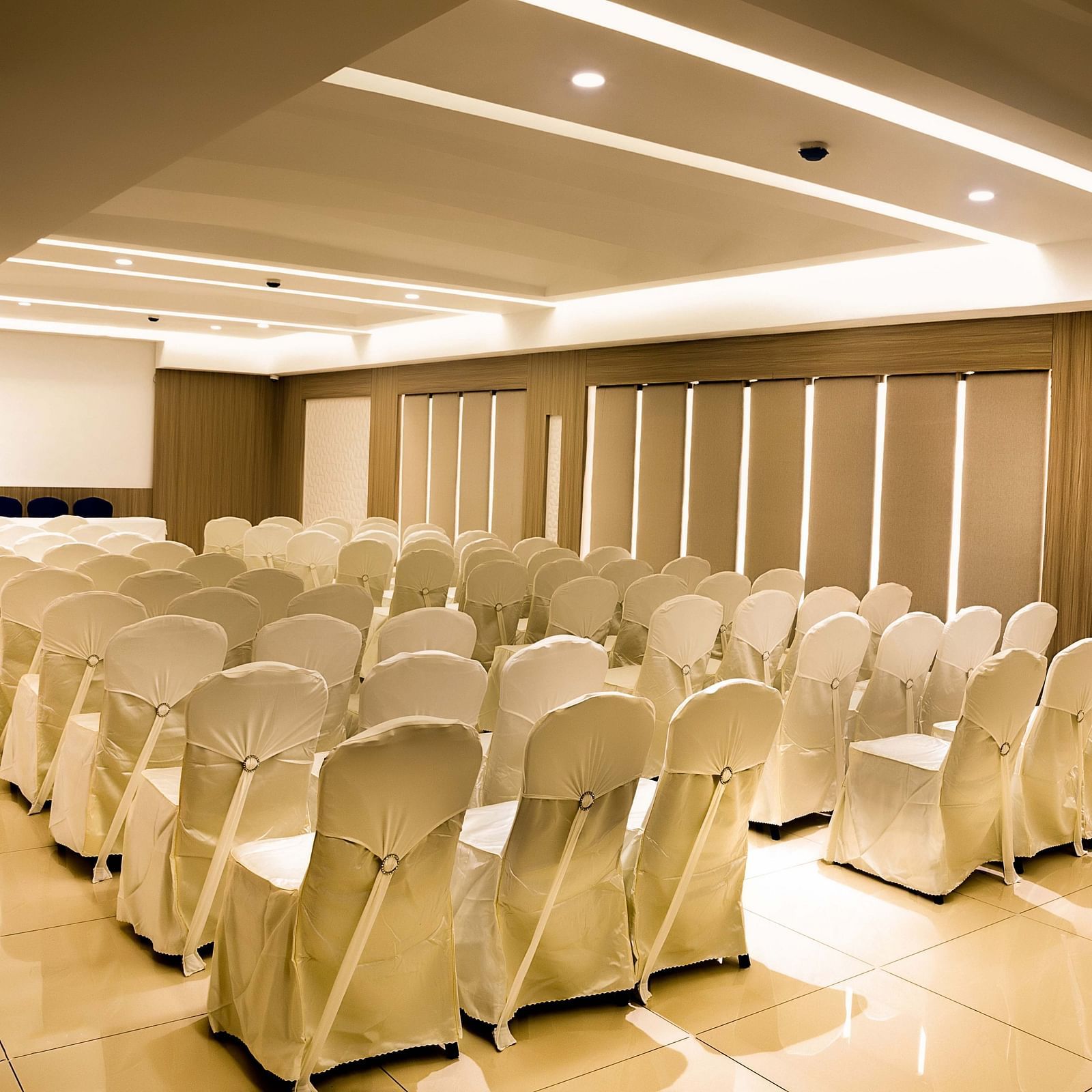 view of event hall with white chairs and warm lights of The Mayberry, Tiruppur