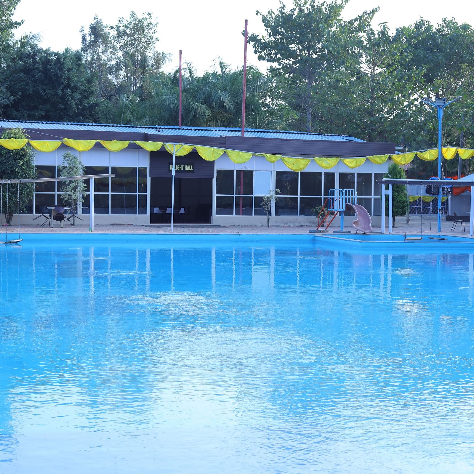 A swimming pool at The Meenakshi Resort by Welcome Inn Hospitality, Bangalore.