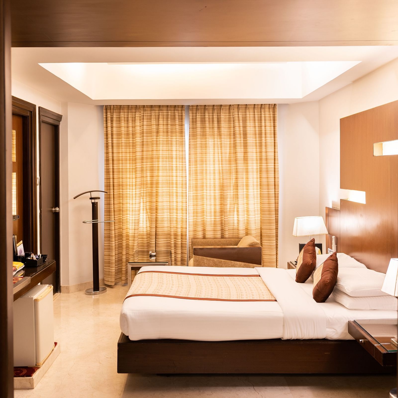  A side view of the cosy room with plushy bed at The President Hotel Jayanagar, Bangalore