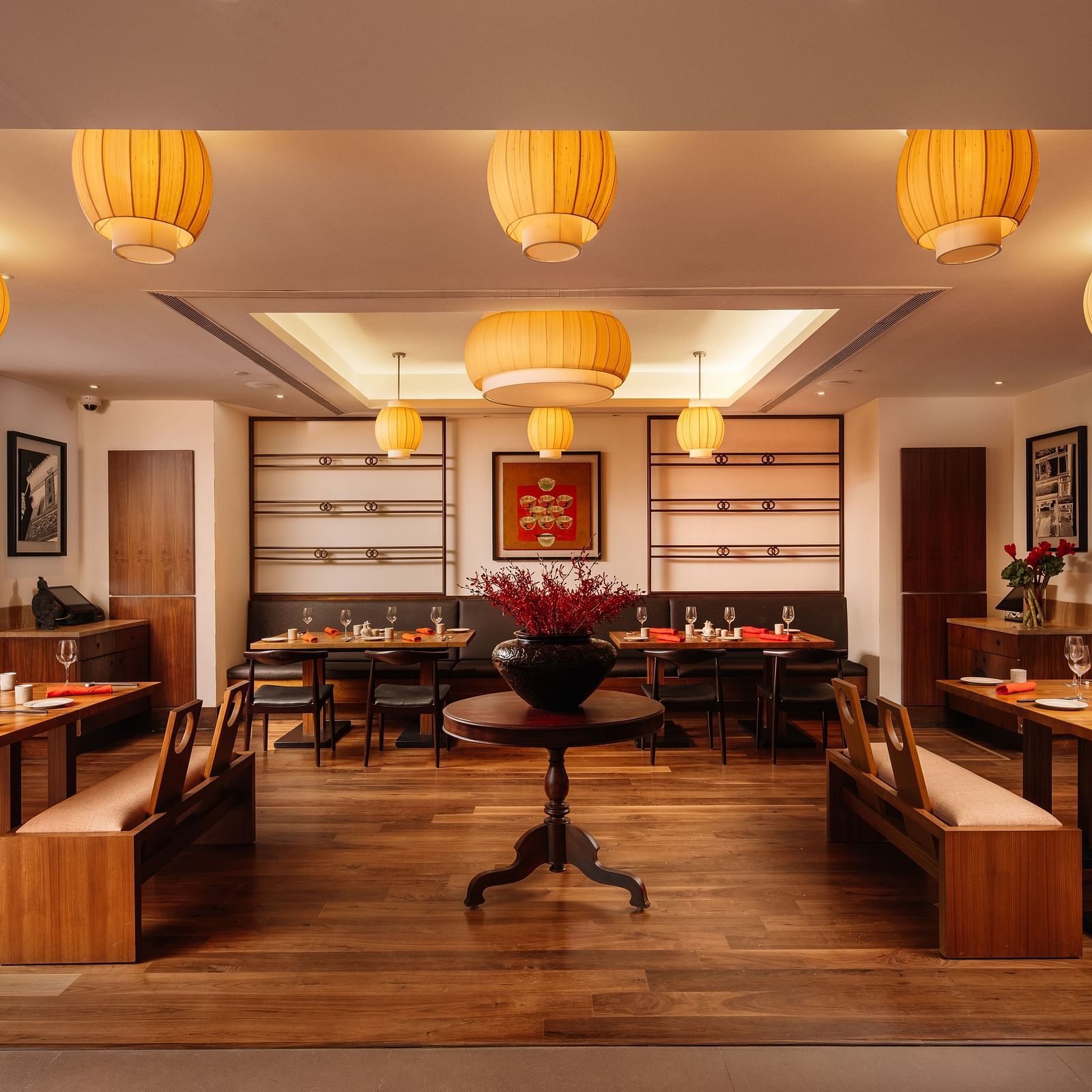A restaurant with wooden seating arrangements and lantern hanging from the ceiling at The Raintree Hotel, St. Mary's Road.