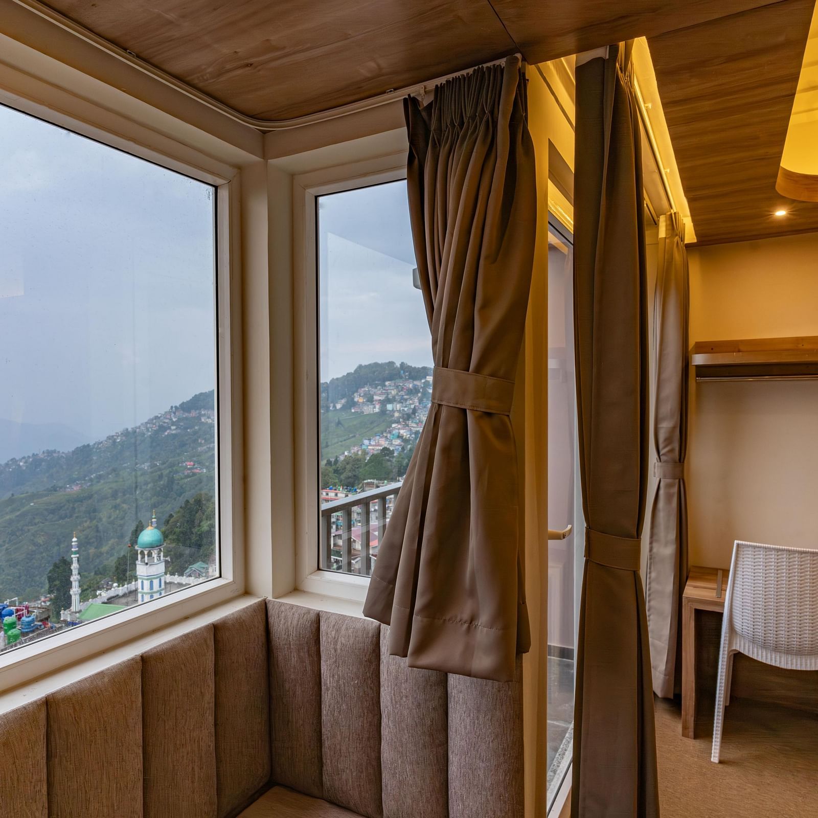 image of the premium room with a huge window exposing serene mountain views at The Soma Hotel by Avianna Group, Darjeeling