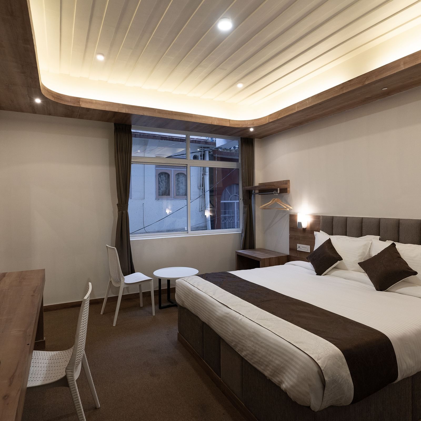 image of the Standard room with a king size bed and a window in the corner at The Soma Hotel by Avianna Group, Darjeeling