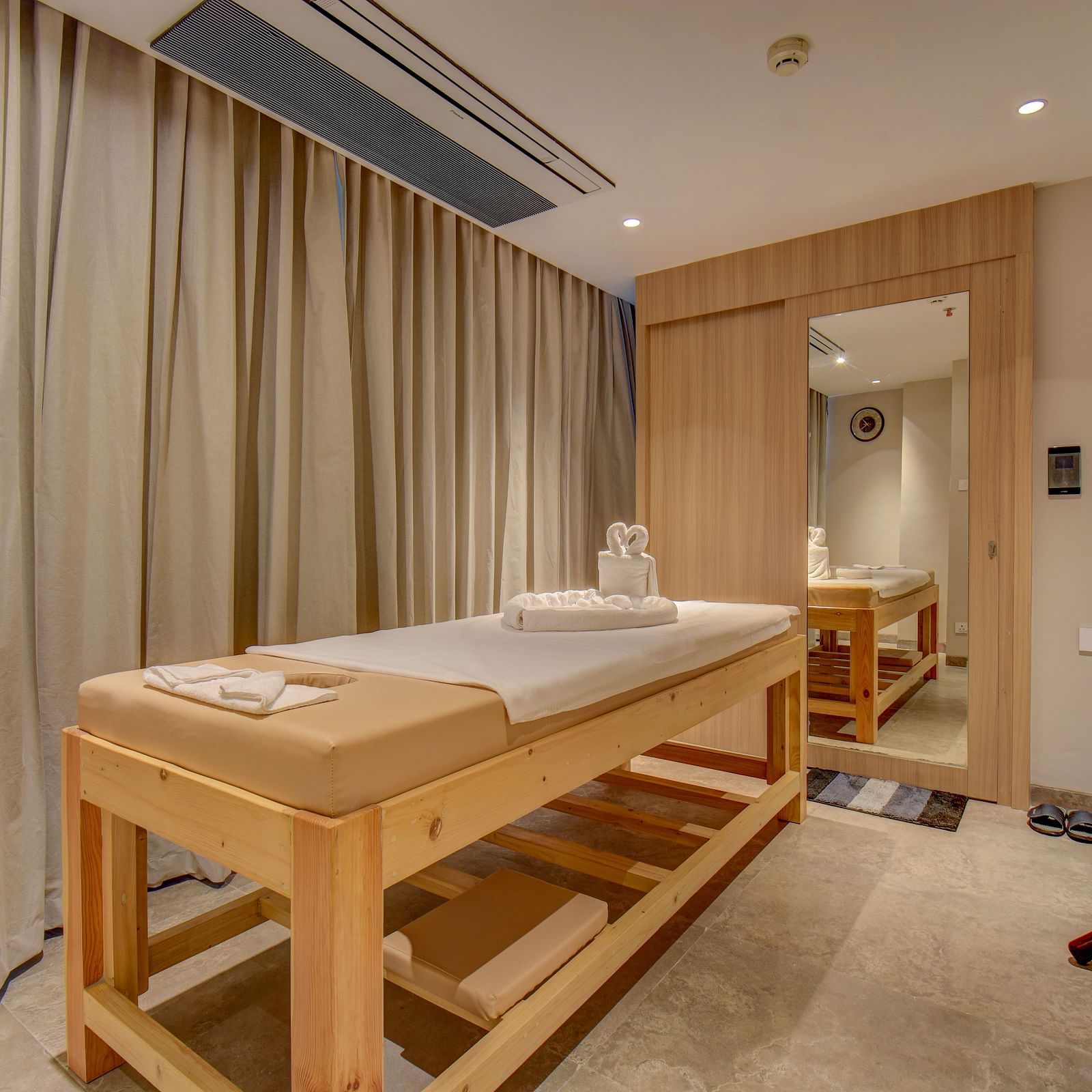 A Spa bed at The SSK Solitaire Boutique Hotel & Spa, Gangapur Road - Nashik featuring a towel and mirror.