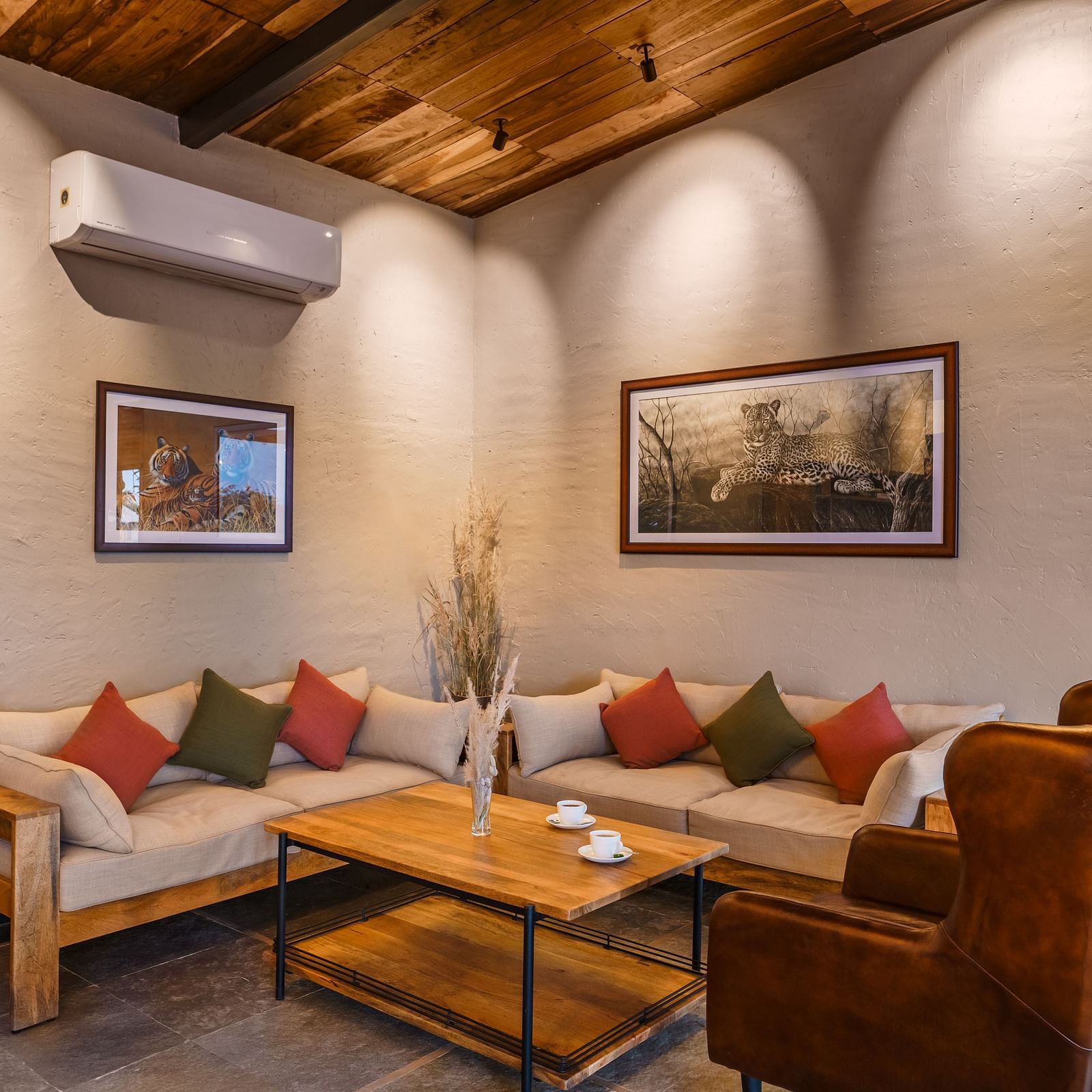Cosy sofas and an armchair at the lounge at Trees N Tigers, Tadoba.