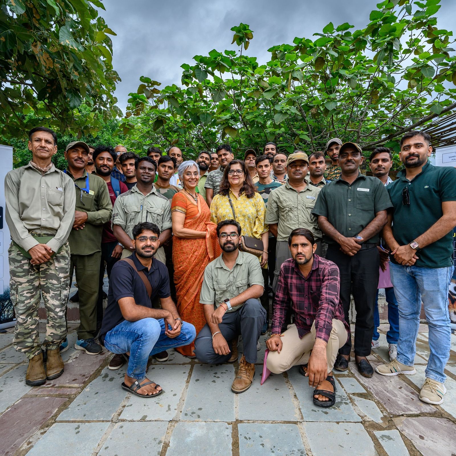 A group of people posing with banners behind them - Utsav Camp