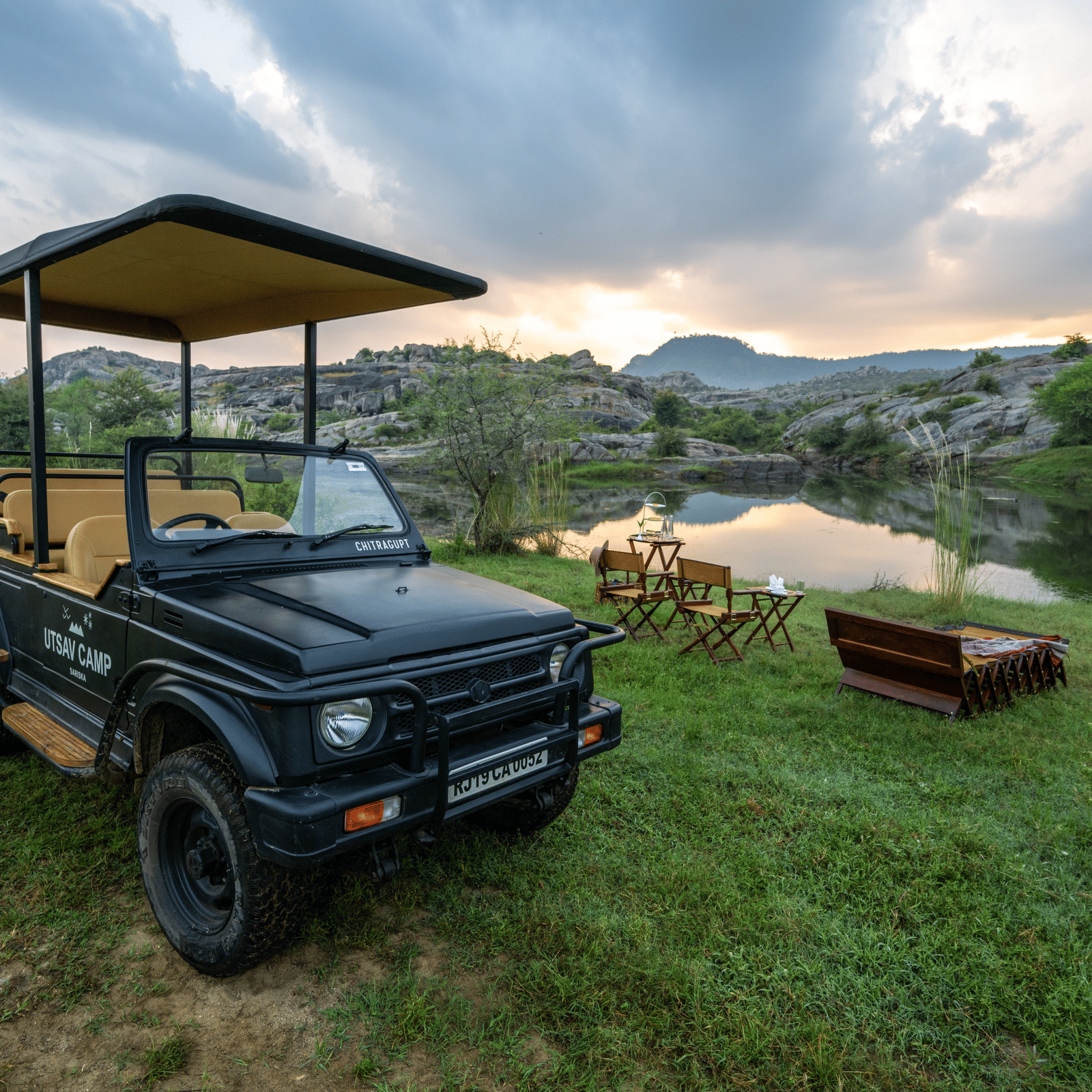 An image of a jeep parked amidst an open field with greenery - Utsav Camp Sariska