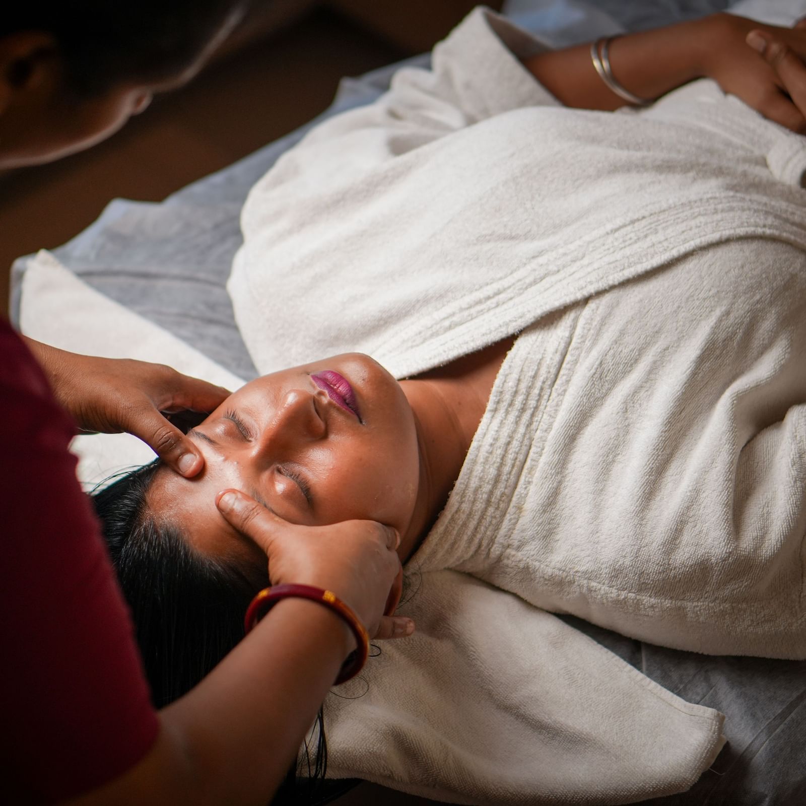 Forehead massage in Vedic Village Spa Resort, featuring a soothing touch during a spa treatment.