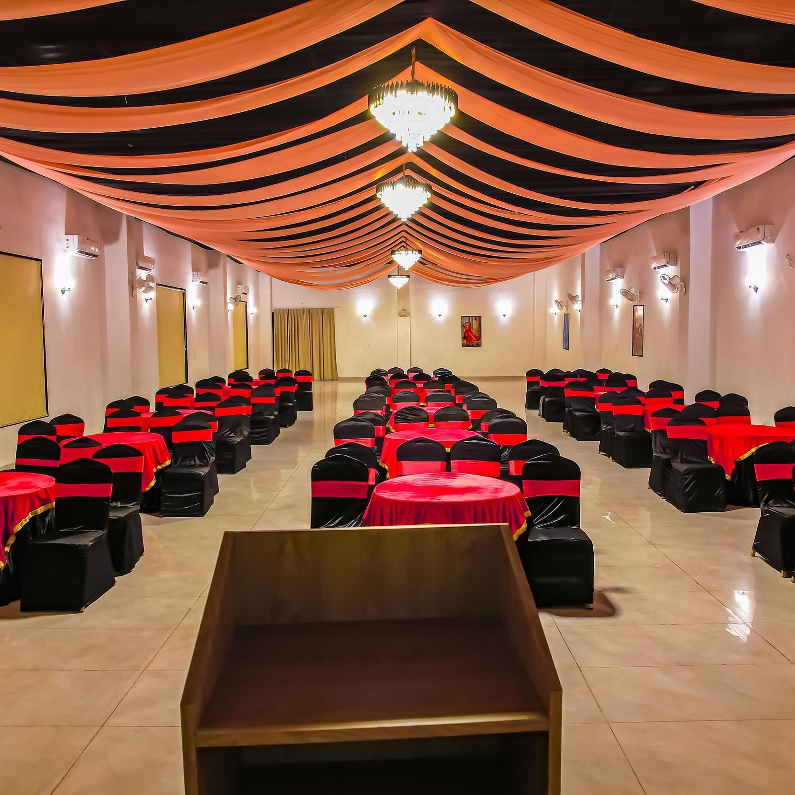 Another view of an empty banquet hall at Vedikant Resorts The Mallard Corbett displays rows of chairs and tables under a decorated ceiling.