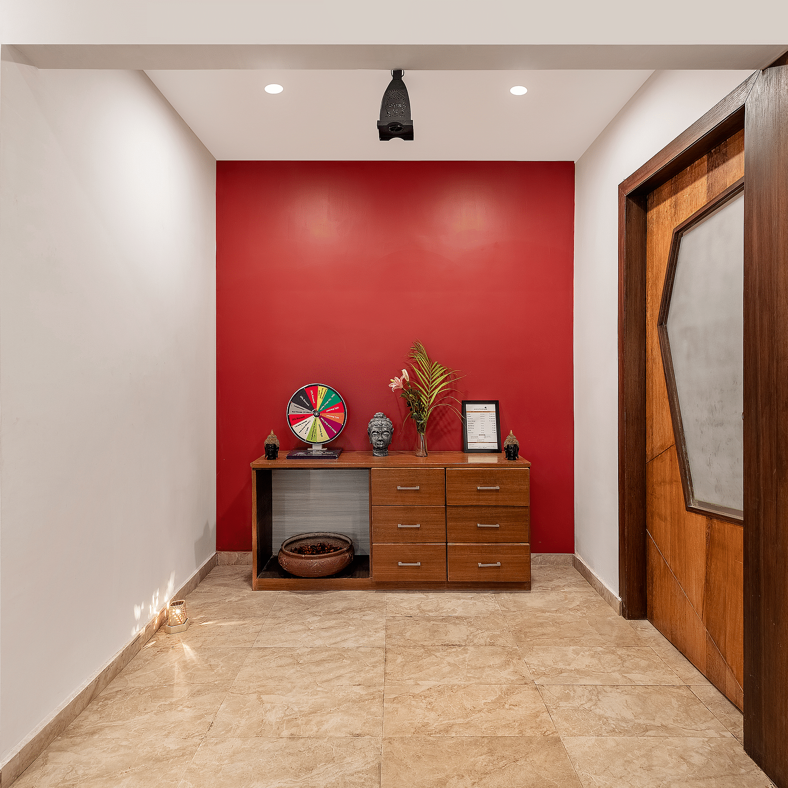A hallway with a cabinet against a wall, decorations, and a door on the right - Via Lakhela Resort & Spa, Kumbhalgarh