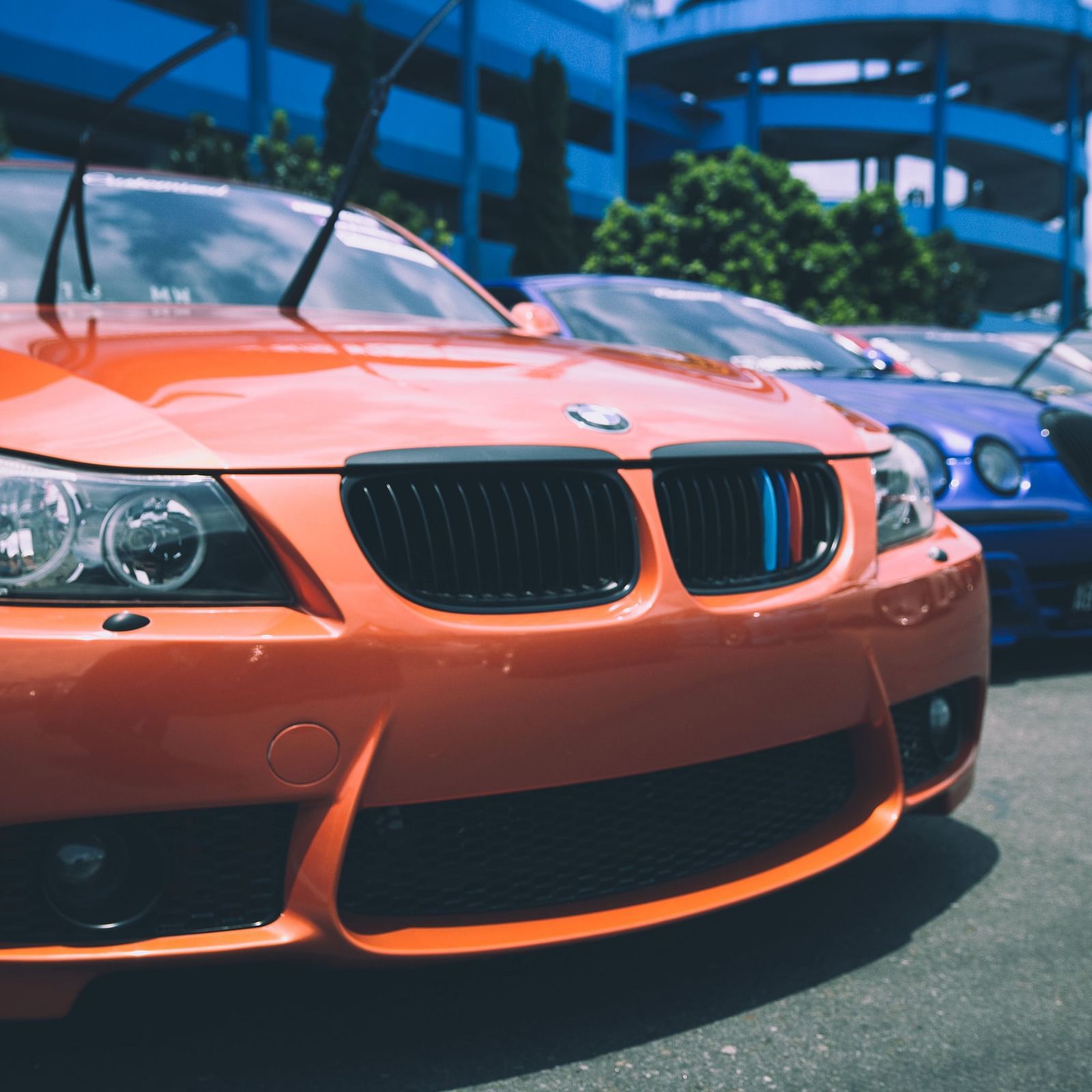 Image of multiple cars parked in a parking lot with a building in the background