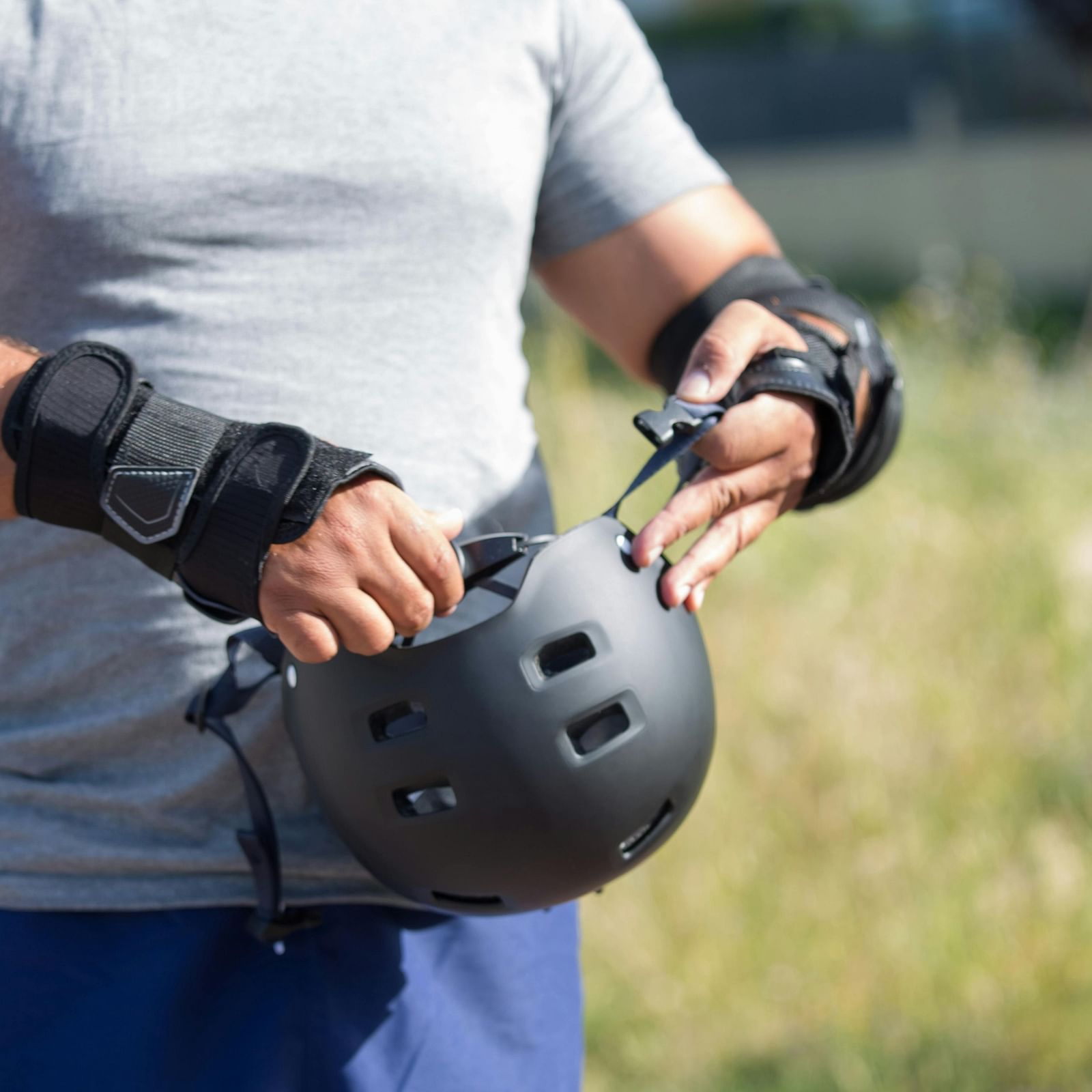 Person in Gray Shirt Holding a Black Helmet