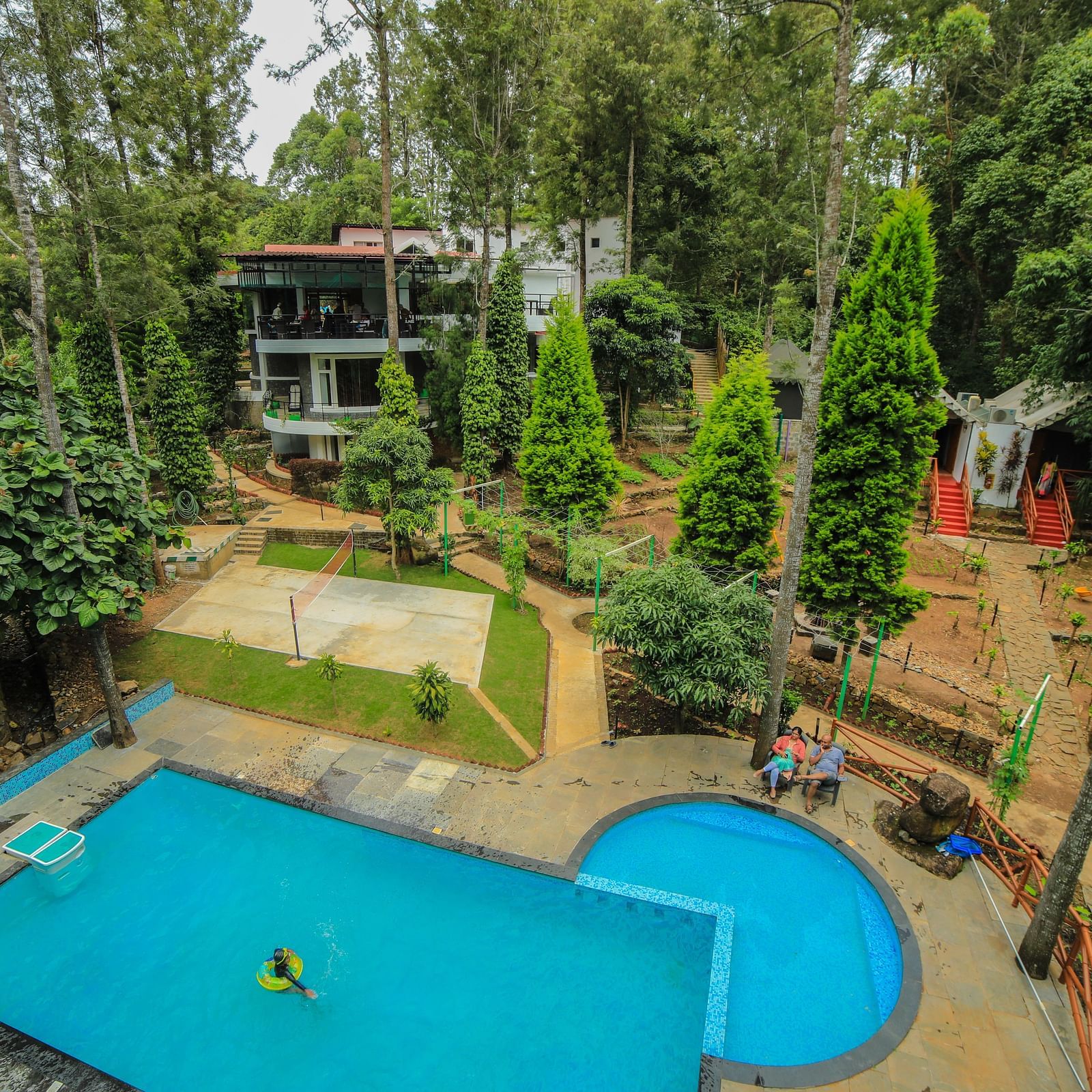 Aerial view of a swimming pool with tress surrounding it at WOW Bison Woods.