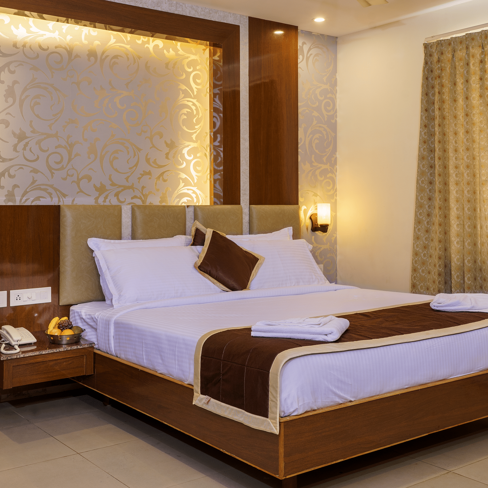 A room at Wyt Hotels, Rameswaram featuring a double size bed, bedside table, and lights installed behind the walls.