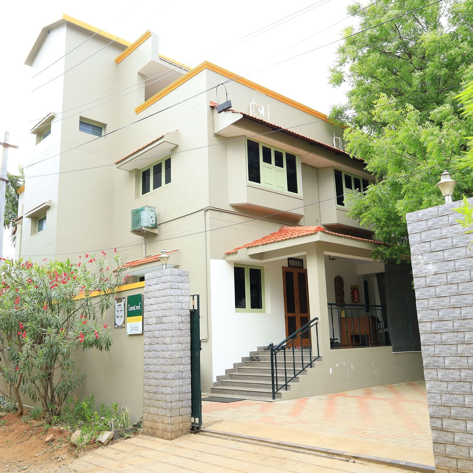 A two story house with a white facade and a green roof.