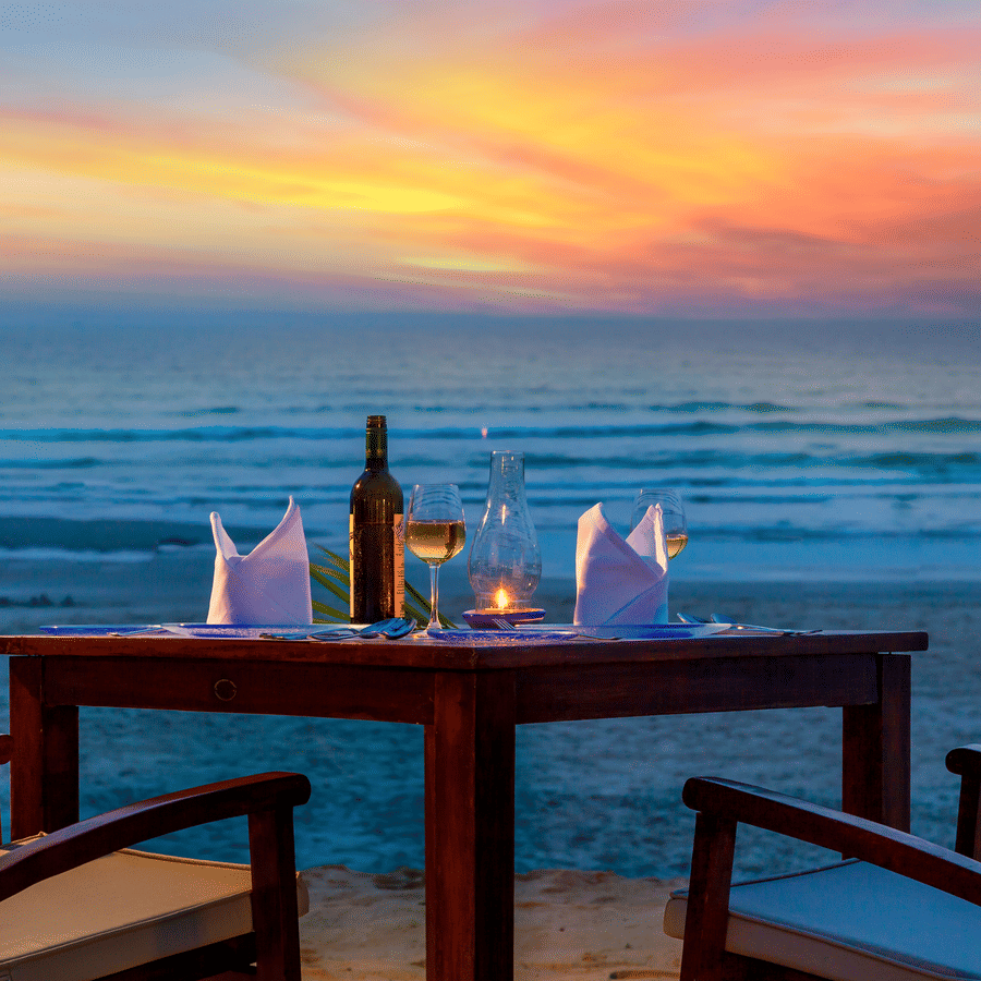 two chairs and a table set up near the beach - Private dining at Caravela Beach Resort Goa