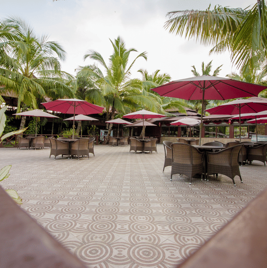 Outdoor seating area of Buddha Garden, offering delectable seafood in Havelock, featuring wicker chairs, garden umbrellas, and surrounding coconut trees.