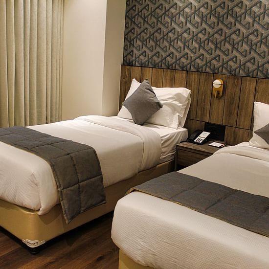 Twin beds in hotel with white and grey bedding at Maxxvalue Hotel MIDC,  Mumbai