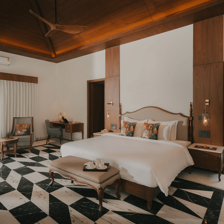 A corner view of the room at The Ananta Udaipur with a king sized bed, a flat-screen TV.