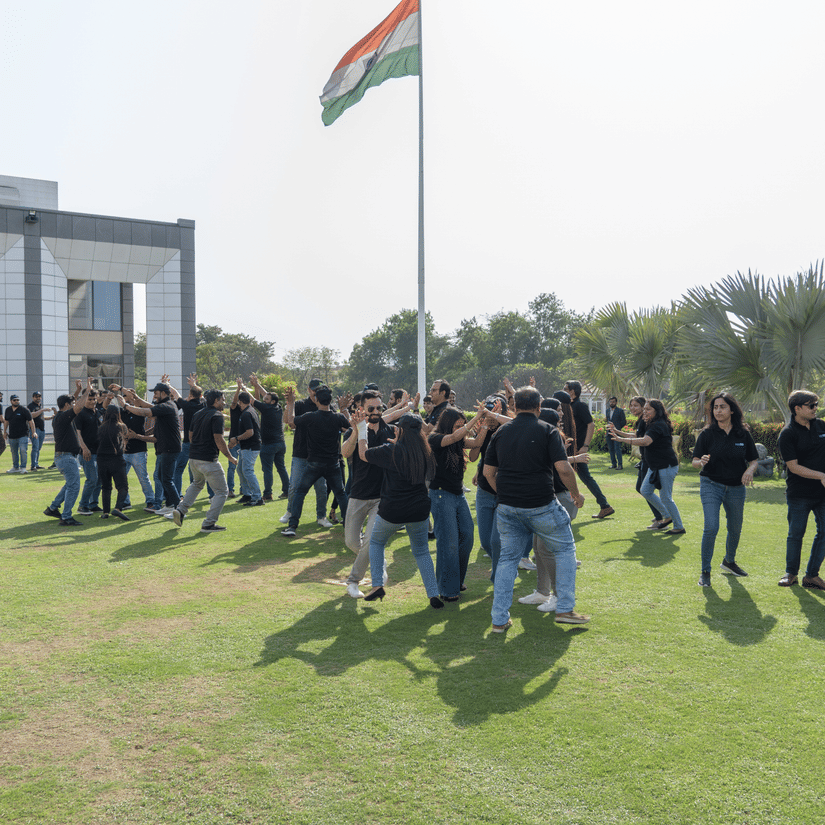 A group of people playing a game near the flagpole - Karma Lakelands.