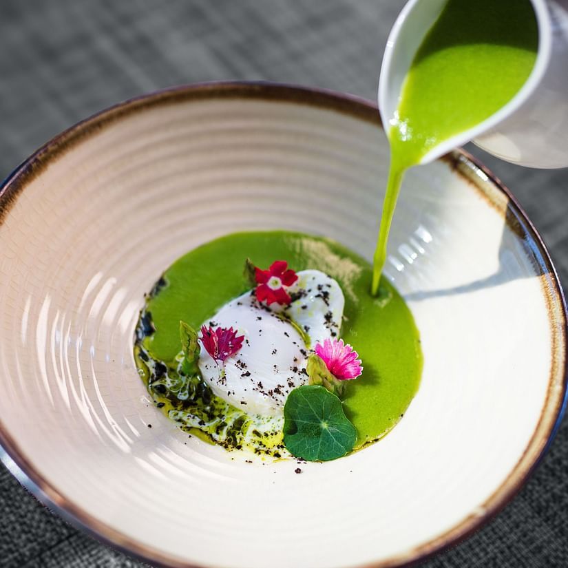 green sauce being poured on a dish