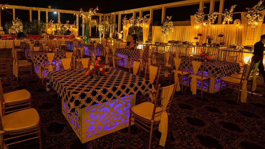 Outdoor evening event setting with festive lighting, banquet tables, and decorative elements under the night sky at Voyage Milestone Hotel and Banquet Siliguri