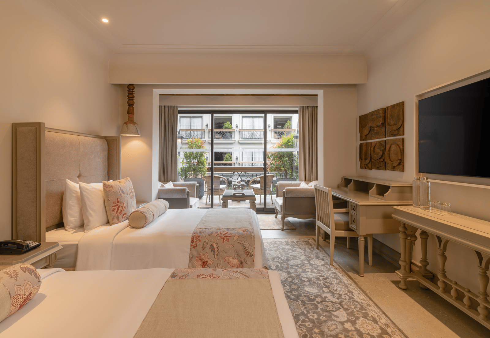 Side view of the Premium Room with a twin bed featuring wide french windows at the far end of the room at The Evren, Vagator.